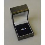 A sapphire and diamond ring, the central square sapphire having diamonds on either side,