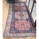 An antique Caucasian runner, the blue ground with four geometric panels, 2.50 m x 1.