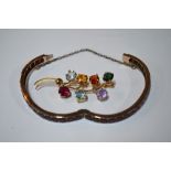 A multi-stone brooch in the form of flower spray to/w garnet set yellow metal bangle with concealed
