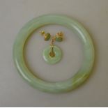 A Chinese green stone bangle to/w pair of green stone stud earrings for pierced ears and a green