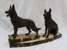An Art Deco style figure group of two bronzed spelter models of German shepherds, one standing,
