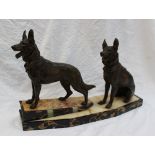 An Art Deco style figure group of two bronzed spelter models of German shepherds, one standing,