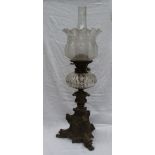 A Victorian oil lamp with an etched glass shade, faceted glass reservoir and a leaf scrolling bronze