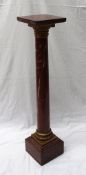 A red marble pedestal, the square top on a gilt metal collar above a tapering column ,