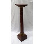 A red marble pedestal, the square top on a gilt metal collar above a tapering column ,