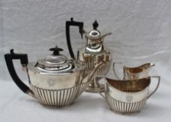 A George V silver four piece teaset of oval form with a gadrooned body comprising a hot water jug,