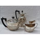 A George V silver four piece teaset of oval form with a gadrooned body comprising a hot water jug,