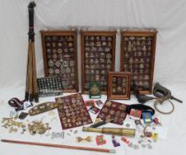 A large quantity of military cap and uniform badges contained in four glazed cabinets and some