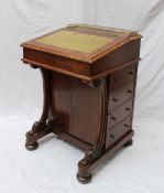 A Victorian walnut Davenport, the three quarter gallery above a sloping writing surface,