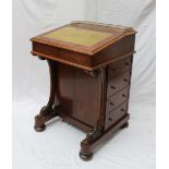 A Victorian walnut Davenport, the three quarter gallery above a sloping writing surface,