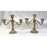 A pair of white metal two branch candelabra with scrolling arms ,