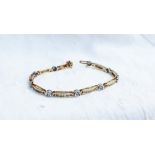 A tennis bracelet set with round brilliant cut diamonds to a yellow metal setting marked 14k,