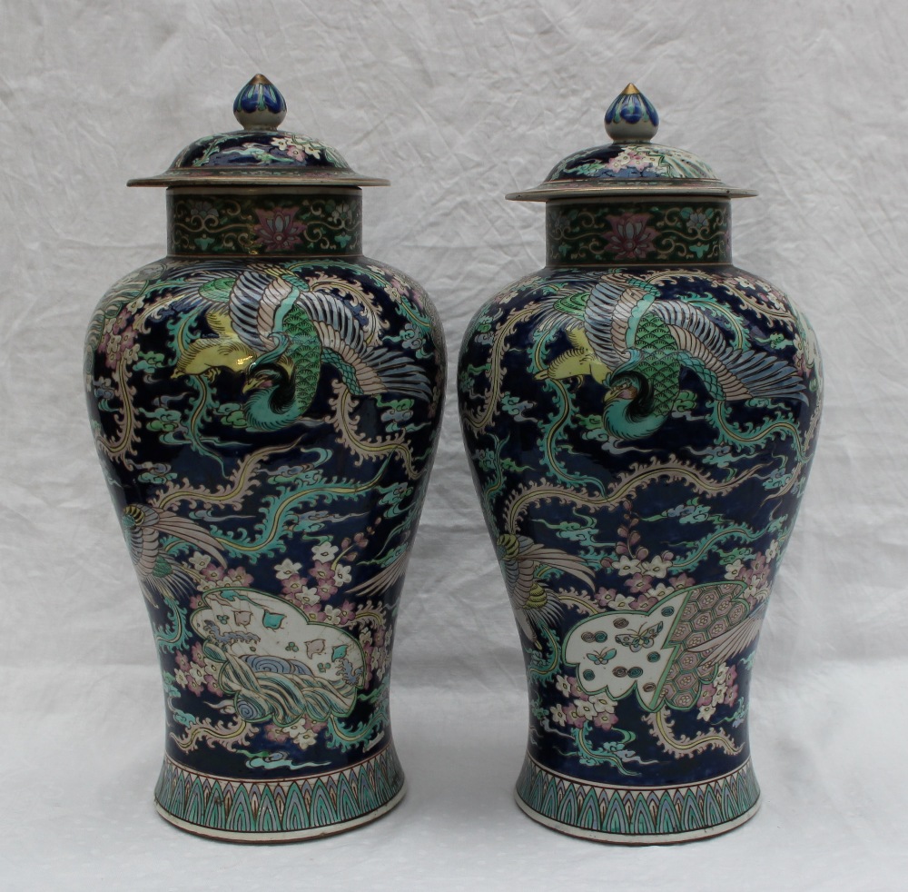 A pair of Chinese porcelain baluster vases and covers with polychrome decoration of butterflies and