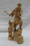 A 19th century Japanese carved ivory figure group depicting a man and a boy stood on rocks with a