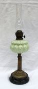 A Victorian oil lamp with a moulded opaque green glass reservoir on a reeded brass column,