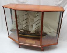 A scratch built model of the "Cutty Sark", contained within a glass case on feet,