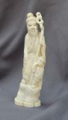 A 19th century Japanese ivory figure group depicting a a man and child holding a staff on a shaped