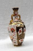 A Royal Crown Derby porcelain twin handled vase decorated in the Imari palette,