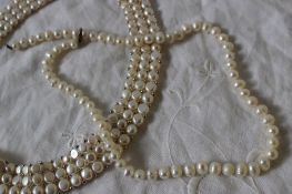 A pearl necklace with 68 barrel shaped pearls together with a three strand pearl choker