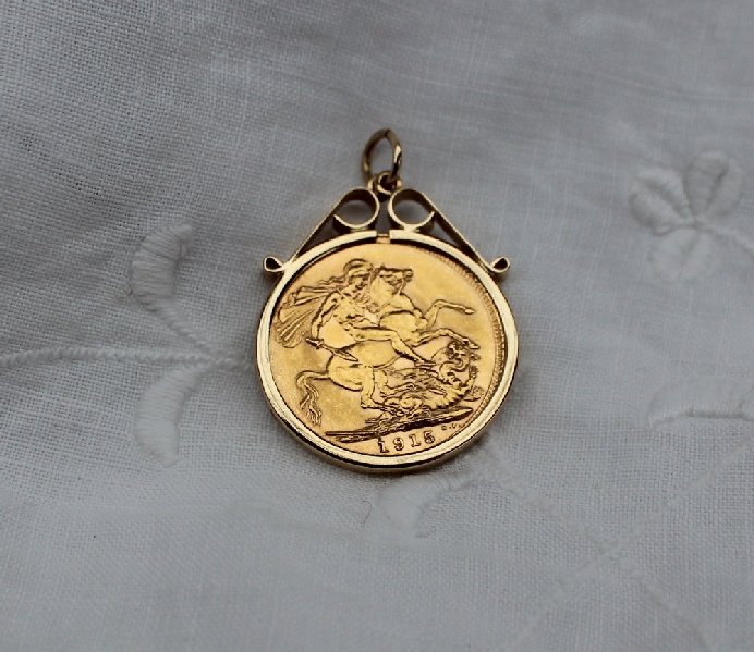 A George V gold sovereign dated 1915 in a yellow metal mount