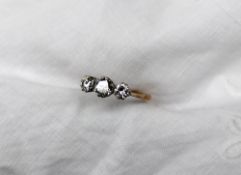 A three stone diamond ring, the central round brilliant cut diamond approximately 0.