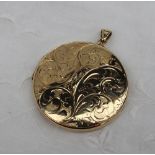 A 9ct yellow gold locket of circular form decorated with scrolling leaves,