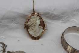 A shell cameo brooch depicting a lady in profile in a yellow metal mount together with a silver