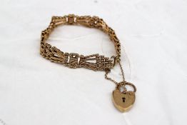 A 9ct yellow gold bracelet with crossover links and a padlock clasp,