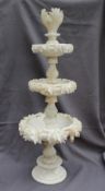 A 19th century alabaster table centrepiece with three tapering dishes carved with leaves on a