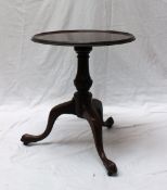A 19th century mahogany tripod table with a dished top and moulded rim on a turned baluster column