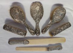 A late Victorian silver backed cased dressing table set comprising a hand mirror,