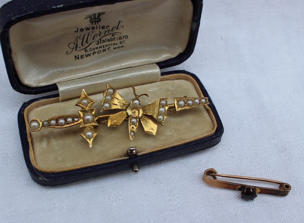 A yellow metal bar brooch in the form of a butterfly set with half pearls, marked 9,