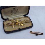 A yellow metal bar brooch in the form of a butterfly set with half pearls, marked 9,