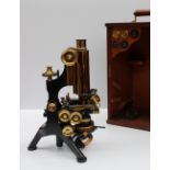 A W Watson and Son lacquered brass and ebonised microscope, with three lenses, a movable platform,