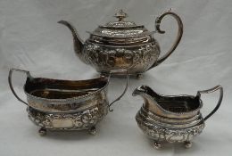 A late George III silver three silver three piece teaset, embossed with flowerheads and leaves,