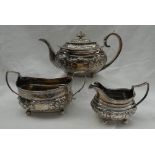 A late George III silver three silver three piece teaset, embossed with flowerheads and leaves,