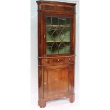 A 19th century mahogany standing corner cupboard with a moulded cornice above a glazed door,