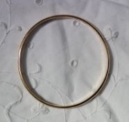 A yellow metal bangle marked k14,