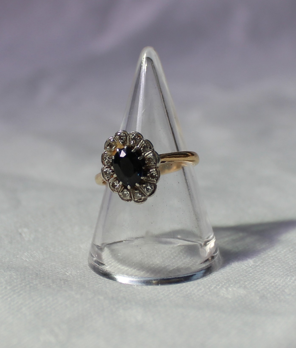 A sapphire and diamond cluster ring set with a central sapphire surrounded by twelve diamonds on a - Image 2 of 3