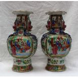 A pair of Cantonese porcelain vases, with a flared rim, applied with dogs of foo, balls and dragons,