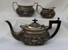 A late Victorian silver three piece teaset of flattened oval form decorated with leaves and lattice