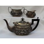 A late Victorian silver three piece teaset of flattened oval form decorated with leaves and lattice