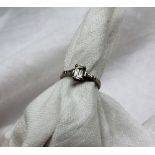 A solitaire diamond ring, the emerald cut diamond measuring 5mm x 4mm x 2mm,