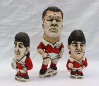 Three John Hughes pottery Groggs of rugby players in Welsh kit, including Mark Jones, 24cm high,