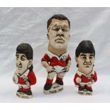 Three John Hughes pottery Groggs of rugby players in Welsh kit, including Mark Jones, 24cm high,