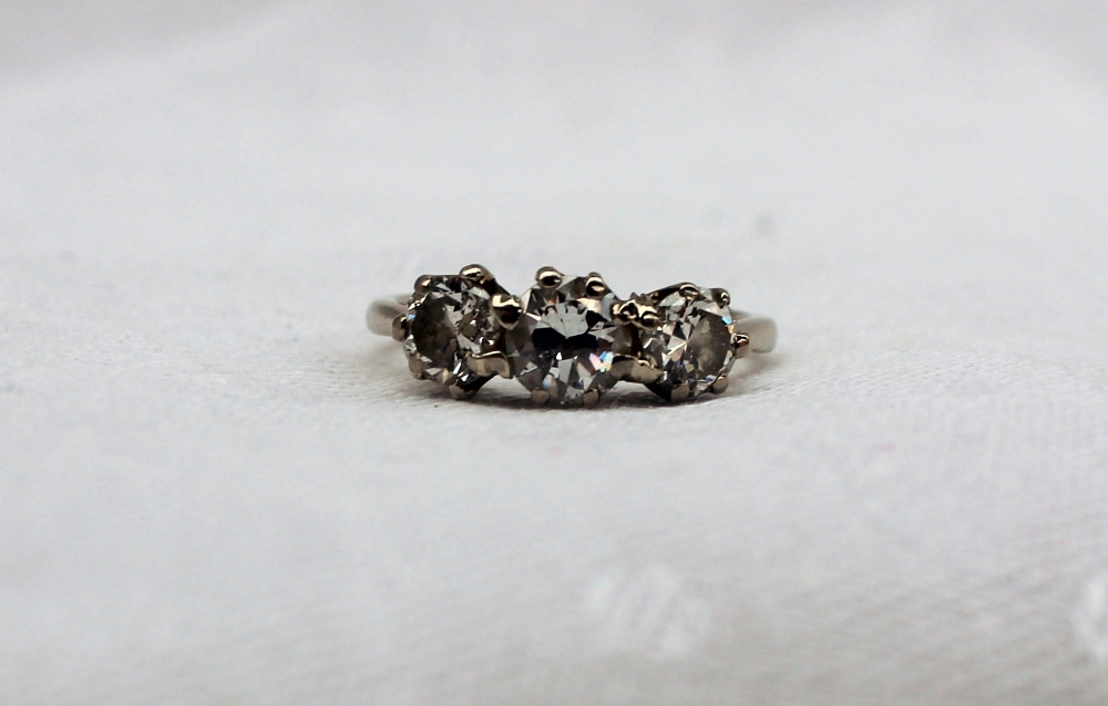 A three stone diamond ring set with a central brilliant cut diamond approximately 0. - Image 7 of 9