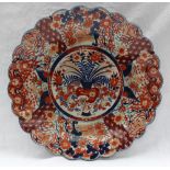 A large Japanese Imari charger decorated with a vase of flowers,