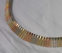 A three colour 14ct gold fringe necklace, with graduated textured panelled links,