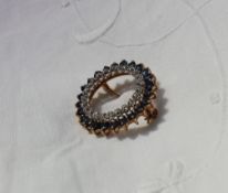 A sapphire and diamond hoop brooch the hoop of claw set brilliant cut diamonds within a surround of