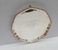 An Elizabeth II silver salver, with a gadrooned rim on three scrolling legs,